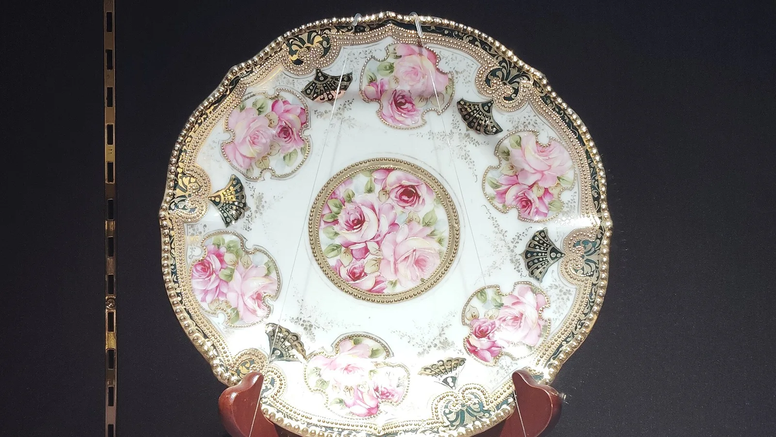 Antique Noritake plate with pink roses and gold decoration on a stand